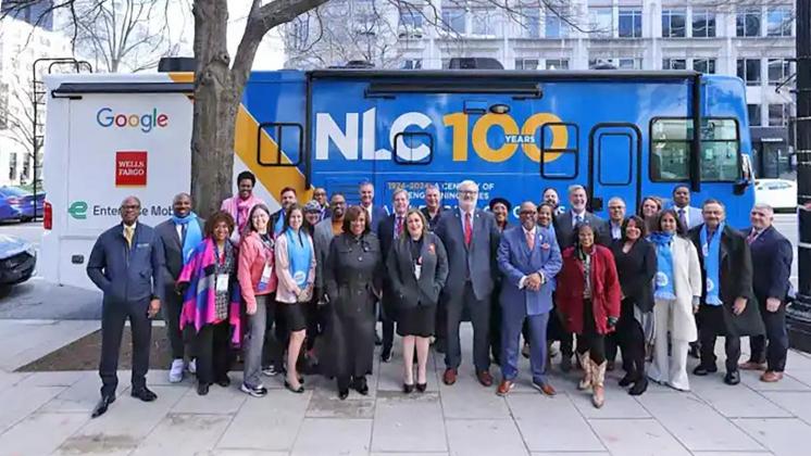 The NLC Board of Directors in front of the newly unveiled Roadshow RV at Congressional City Conference in March 2024.