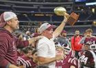 Head Coach Chris Ross hoists the Area Round Championship trophy over his Hawks football team at AT&T Stadium.